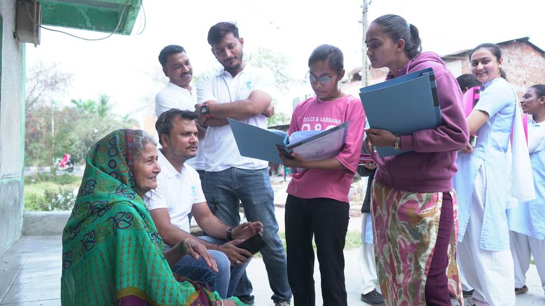 Foundation team member speaking with an elderly community member during a doorstep survey